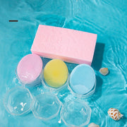 Soft silicone baby shampoo brushes in pink, yellow, and blue with ergonomic grip and protective cases on blue water background