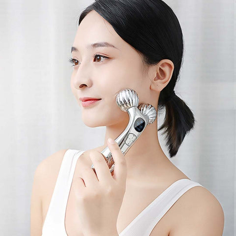 Woman using a silver facial massager roller for skin lifting and tightening