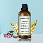 Bottle of aloe base oil with splash effect and decorative stones and flower